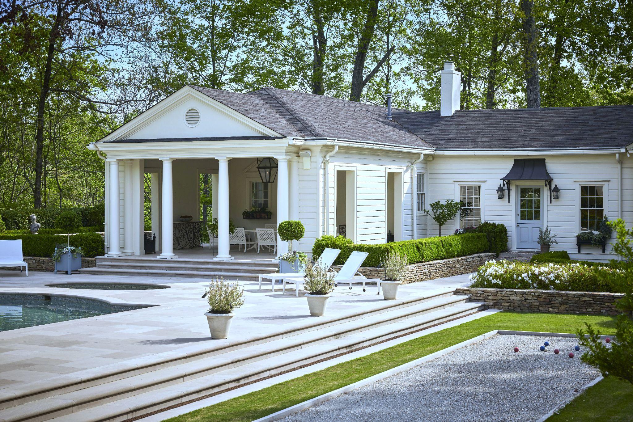 Luxury backyard with pool patio, covered outdoor living area, manicured hedges, and bocce court at an elegant Atlanta estate.